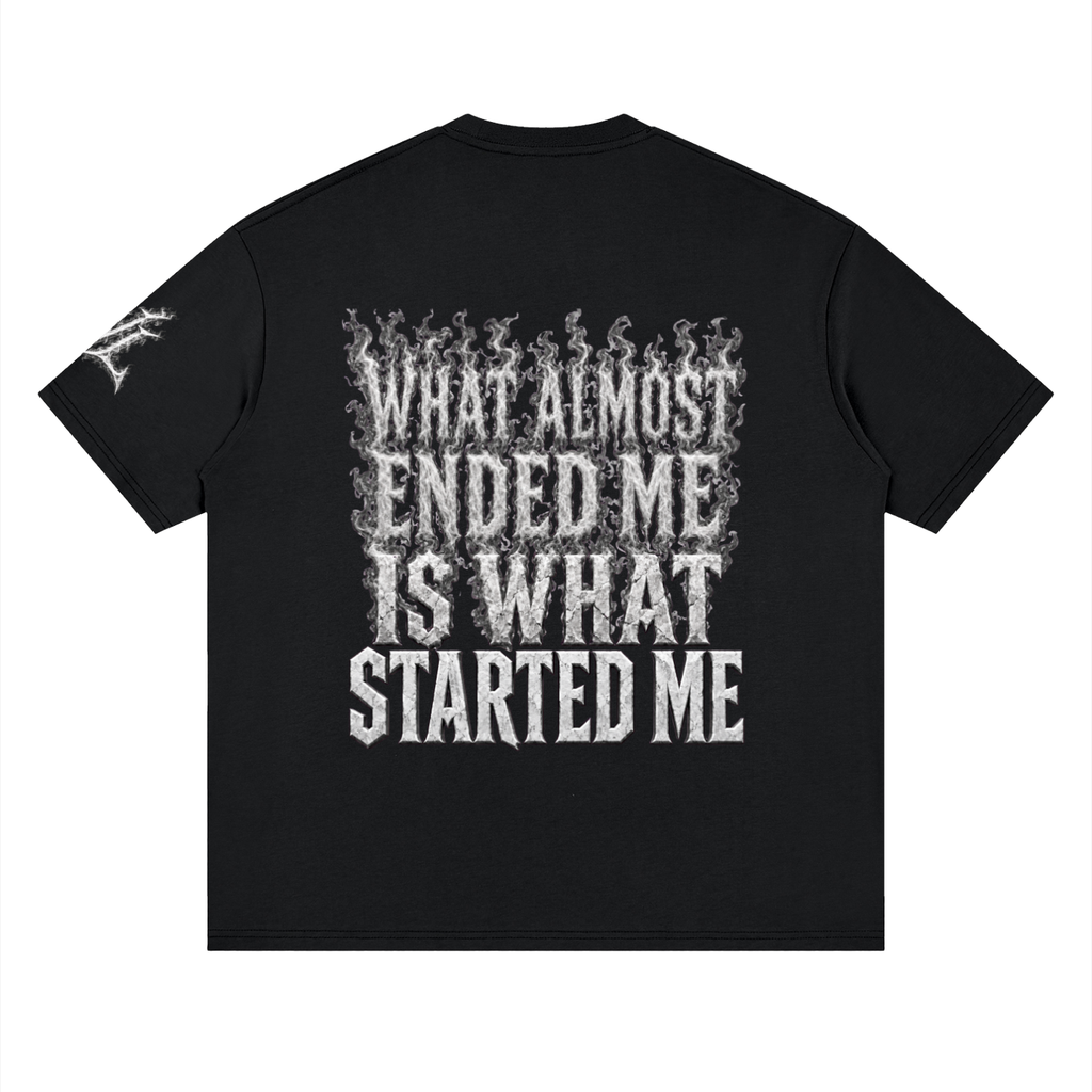 Back view of black WHYELUME What Started Me drop shoulder tee with white smoke What Almost Ended Me Is What Started Me graphic
